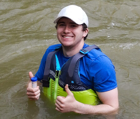 Miami University Alumni, Adam Smith, in the Whitewater River doing research.
