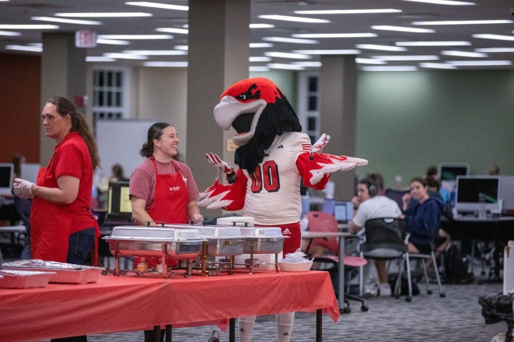 Miami University Swoop talking with volunteer at event on campus. 