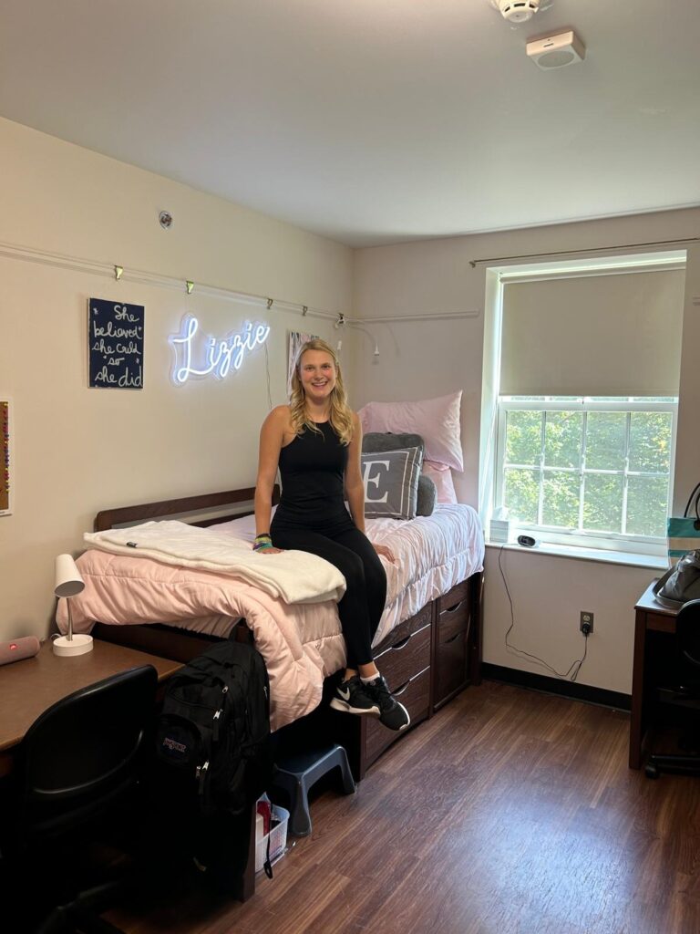 Miami international student Elizabeth sitting on her freshman year dorm room bed